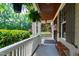 Inviting front porch with ferns hanging from the ceiling and a wooden bench, offering a relaxing outdoor space at 101 Eden Glen Dr, Holly Springs, NC 27540