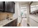 Hallway featuring beautiful dark cabinets with stainless steel sink and access to a white kitchen at 101 Eden Glen Dr, Holly Springs, NC 27540
