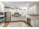 A spacious kitchen featuring white cabinets, stainless steel appliances, and granite countertops at 101 Eden Glen Dr, Holly Springs, NC 27540