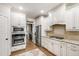 Modern kitchen with stainless steel appliances, white cabinetry, and a beautiful backsplash at 101 Eden Glen Dr, Holly Springs, NC 27540