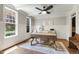 Sunlit office with a ceiling fan, decorative wainscoting, large windows, and hardwood floors, creating a professional ambiance at 101 Eden Glen Dr, Holly Springs, NC 27540
