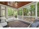 Charming screened-in porch featuring cozy seating, a decorative rug, and tranquil views of the surrounding greenery at 101 Eden Glen Dr, Holly Springs, NC 27540