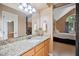 Well-lit bathroom with granite counters, light wood cabinets, and view into the main bedroom at 102 Legacy Ln, Durham, NC 27713