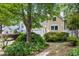Beautifully landscaped front yard featuring mature trees, shrubbery, and walkway to front door at 102 Legacy Ln, Durham, NC 27713