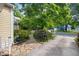 Home's driveway and walkway with natural landscaping on a tree-lined street at 102 Legacy Ln, Durham, NC 27713