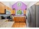 Bright kitchen with stainless steel appliances, natural wood cabinets, hardwood floors, and granite countertops at 102 Legacy Ln, Durham, NC 27713