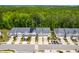 Aerial shot showing townhome exteriors, well manicured lawns, solar panels, and tree lined backdrop in a quiet neighborhood at 1049 Lakebrink Dr, Morrisville, NC 27560