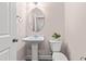Powder room featuring a pedestal sink, oval mirror, and a plant for a touch of greenery at 1049 Lakebrink Dr, Morrisville, NC 27560