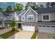 Charming townhome exterior boasts stone accents, solar panels, a two-car garage, and well-manicured landscaping at 1049 Lakebrink Dr, Morrisville, NC 27560