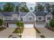 Aerial view of townhomes showcases brick and siding exterior, garages, and driveways at 1049 Lakebrink Dr, Morrisville, NC 27560