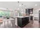 Open-concept kitchen featuring a large island with pendant lighting, stainless steel appliances, and living area access at 1049 Lakebrink Dr, Morrisville, NC 27560