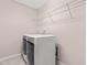 Laundry room features stainless steel washer and dryer with white cabinetry at 1049 Lakebrink Dr, Morrisville, NC 27560