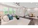 Bright and airy living room featuring large windows, hardwood floors, comfortable seating, and access to the dining area at 1049 Lakebrink Dr, Morrisville, NC 27560