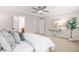 Serene main bedroom featuring a tray ceiling, ceiling fan, and a view into the en suite bathroom at 1049 Lakebrink Dr, Morrisville, NC 27560