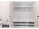 Mudroom with white shelving, coat hooks, and bench seating for convenient storage and organization at 1049 Lakebrink Dr, Morrisville, NC 27560
