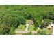 Aerial view of the property showcasing a well-maintained home with a long driveway and a densely wooded perimeter at 110 Lexington Ave, Zebulon, NC 27597