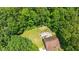 Aerial view of the backyard highlighting the patio area with an outdoor fireplace nestled in a wooded setting at 110 Lexington Ave, Zebulon, NC 27597