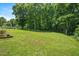Expansive backyard with mature trees and a level lawn, offering endless possibilities for outdoor activities at 110 Lexington Ave, Zebulon, NC 27597