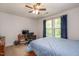 Bedroom with a blue comforter on the bed, a desk, and natural light coming through the windows at 110 Lexington Ave, Zebulon, NC 27597