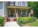 Inviting covered front porch with seating and decorative landscaping at 110 Lexington Ave, Zebulon, NC 27597