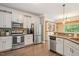 Kitchen with stainless steel appliances, granite countertops, a mosaic backsplash, and white cabinets at 110 Lexington Ave, Zebulon, NC 27597