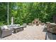 Outdoor patio features stone fireplace, bar, and comfortable seating, perfect for entertaining in a private, wooded setting at 110 Lexington Ave, Zebulon, NC 27597