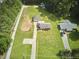 Aerial view of property with home, detached garage, and spacious green lawn surrounded by trees at 1105 Horseshoe Rd, Durham, NC 27703