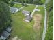 This image shows an aerial perspective with a house, garage, additional outbuildings, and long driveway at 1105 Horseshoe Rd, Durham, NC 27703
