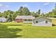 Spacious backyard showcasing a home's exterior, lush lawn, and various structures on a sunny day at 1105 Horseshoe Rd, Durham, NC 27703