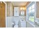Bright bathroom featuring a window, classic white fixtures, and neutral toned walls at 1105 Horseshoe Rd, Durham, NC 27703