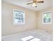A sunny bedroom with two windows and a ceiling fan at 1105 Horseshoe Rd, Durham, NC 27703