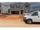 Unfinished two-story home featuring gray siding, an attached two-car garage, and professional equipment at the front at 1138 Winding Spring Dr, Mebane, NC 27302