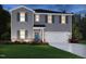 Charming two-story home features gray siding, dark shutters, an attached two-car garage, and green grass at 1138 Winding Spring Dr, Mebane, NC 27302