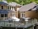 Multi-level deck featuring a hot tub, outdoor dining area, and stone fireplace at 11425 Horsemans Trl, Raleigh, NC 27613