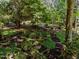 Lush backyard garden with mature trees, terraced landscaping, and a stone pathway at 11425 Horsemans Trl, Raleigh, NC 27613