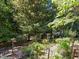 Mature, backyard vegetable garden with a trellised fence, and large trees at 11425 Horsemans Trl, Raleigh, NC 27613
