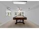 Spacious game room with a full-sized pool table, fan, and bright natural light at 11425 Horsemans Trl, Raleigh, NC 27613