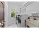 Laundry room featuring a washing machine, dryer, sink, and shelving at 11425 Horsemans Trl, Raleigh, NC 27613