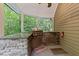 Outdoor kitchen with a built-in barbecue grill, granite countertop, sink, and wood paneled walls at 11425 Horsemans Trl, Raleigh, NC 27613