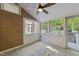 Enclosed sunroom featuring a ceiling fan, tile floor, and large windows with views of the outdoor space at 11425 Horsemans Trl, Raleigh, NC 27613