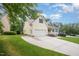 Side view of a two-story yellow home featuring a driveway and well-maintained lawn at 1208 Dunn Creek Xing, Wake Forest, NC 27587