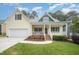 Charming yellow two-story home with a welcoming front porch and attached two car garage at 1208 Dunn Creek Xing, Wake Forest, NC 27587
