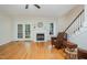 An open living room features hardwood floors, fireplace, and a double door entrance leading to an outdoor area at 1208 Dunn Creek Xing, Wake Forest, NC 27587