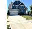 Charming two-story home with blue accents, well-maintained lawn, and a wide driveway leading to an attached two-car garage at 123 Gunderson Ln, Garner, NC 27529