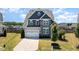 Inviting two-story home with blue and gray facade, manicured lawn, and a spacious driveway leading to a two-car garage at 123 Gunderson Ln, Garner, NC 27529