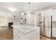 Well-designed kitchen with a marble island, stainless steel refrigerator, and view into the living room at 123 Gunderson Ln, Garner, NC 27529