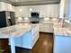 Close-up of a modern kitchen with white cabinetry, marble countertops, and stainless steel appliances and island at 123 Gunderson Ln, Garner, NC 27529