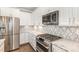 Modern kitchen with stainless steel appliances, marble countertops and backsplash, and white cabinetry at 123 Gunderson Ln, Garner, NC 27529