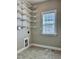 An empty laundry room with ample shelf storage and a window, offering plenty of space for laundry-related tasks at 123 Gunderson Ln, Garner, NC 27529
