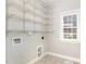 Well-lit laundry room features ample shelving, utility connections, and a window providing natural light at 123 Gunderson Ln, Garner, NC 27529
